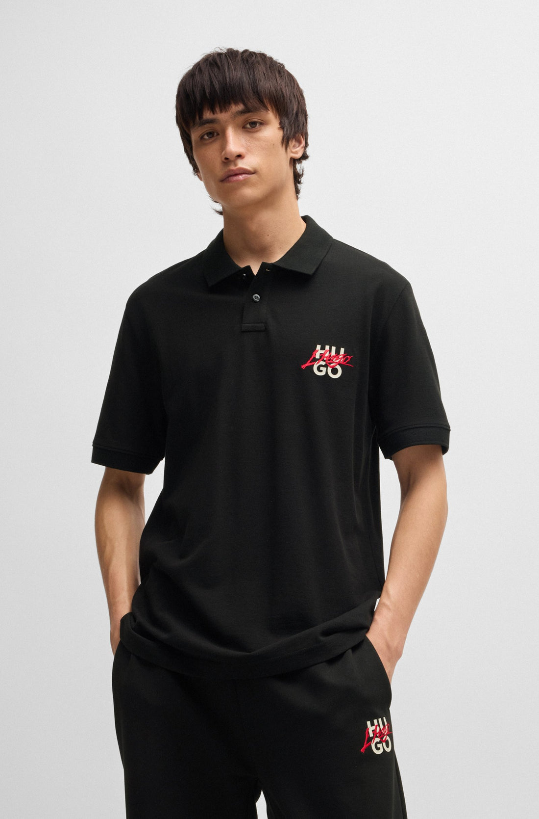 Half-Full look of the HUGO Dalogpolo Logo Graphic Polo Shirt in Black, paired with jeans for a smart-casual outfit.