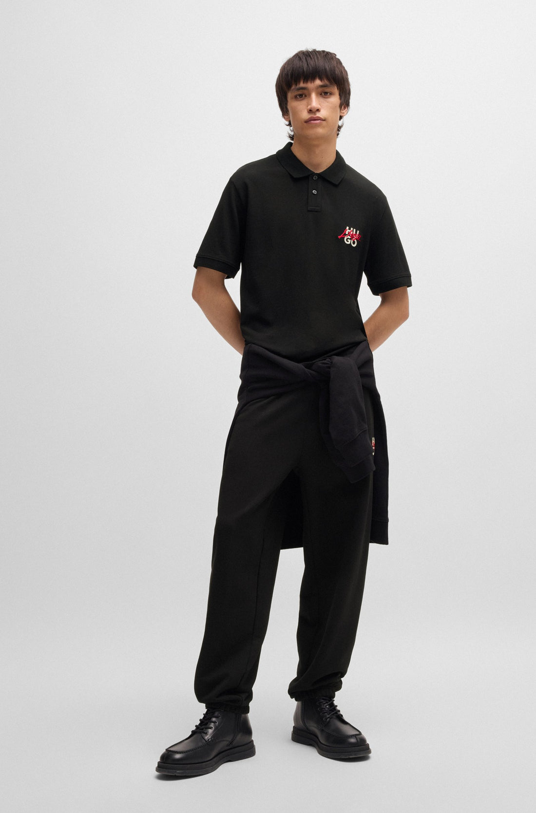 Full look of the HUGO Dalogpolo Logo Graphic Polo Shirt in Black, paired with jeans for a smart-casual outfit.