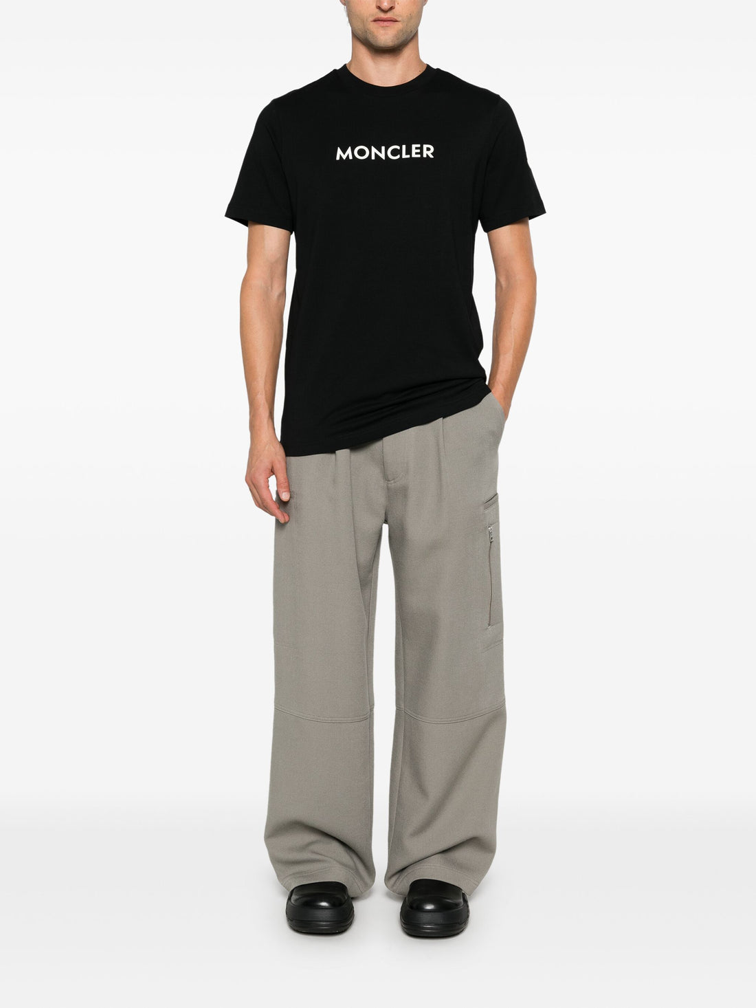 Full look on model of the MONCLER Logo Print Cotton T-Shirt in Black, styled with jeans for a modern, casual outfit.