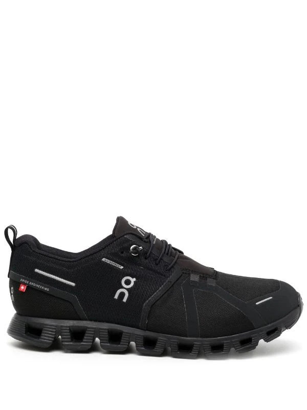 Side view of the ON RUNNING Cloud 5 Waterproof All Black sneakers, highlighting the signature CloudTec sole for ultimate comfort and performance.